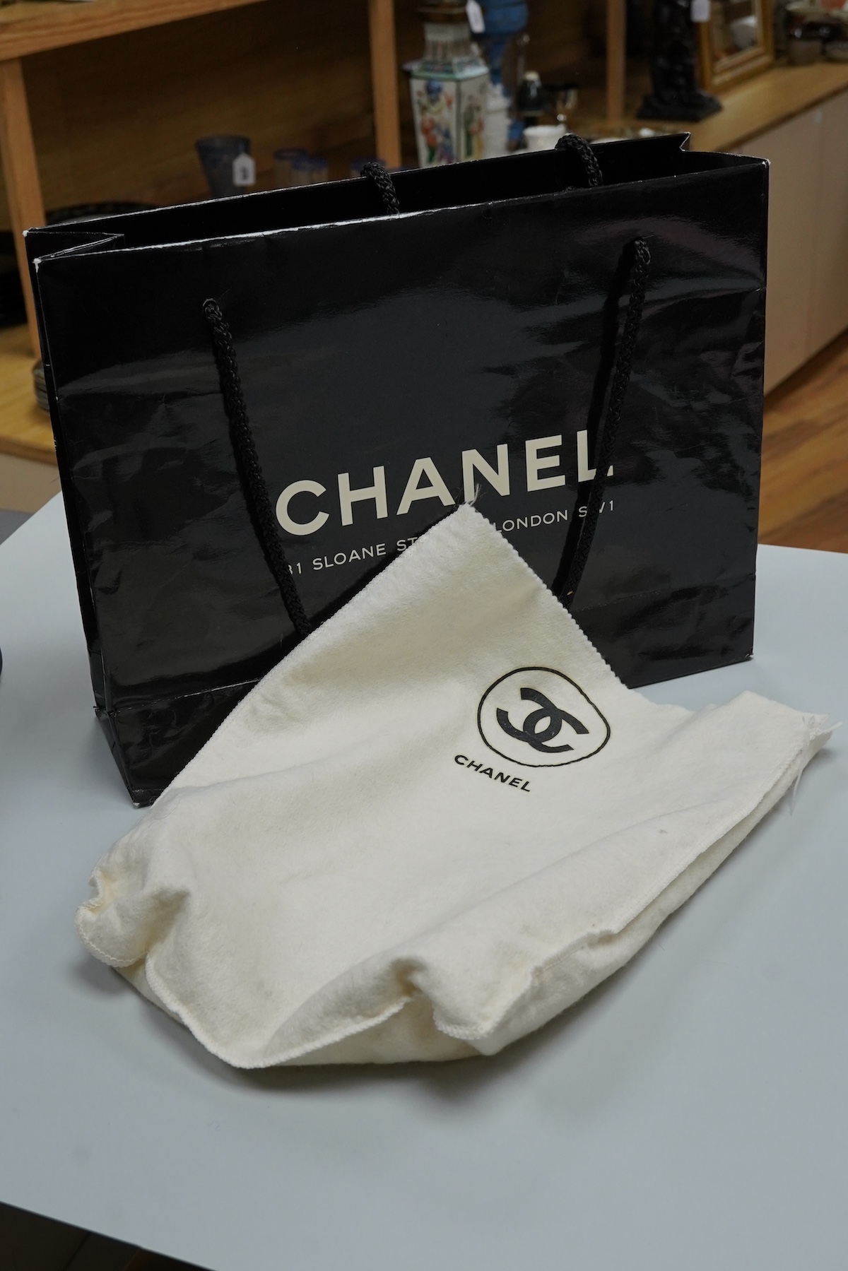 A late 1980’s Chanel black leather Diana shoulder bag with original dust cover and bag, Chanel authenticity card numbered 1944645, interior date code rubbed, 23cm wide, Provenance: Purchased by the vendor, 26 Old Bond St